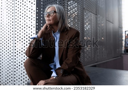 portrait of a well-groomed gray-haired middle-aged woman with a bob hairstyle dressed in a jacket and trousers. middle aged business concept Royalty-Free Stock Photo #2353182329