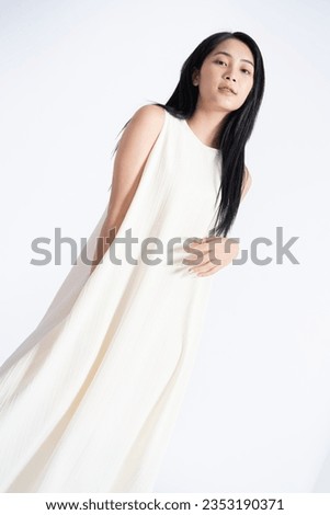 Photo of young Asian girl wearing dress on background