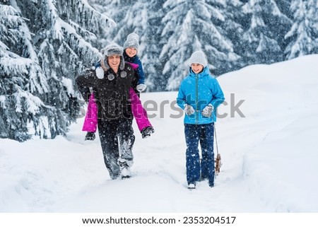 Dad on walk with children in winter. Hiking in the winter mountains. Active outdoor winter games.