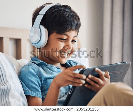 Happy, kid and headphones with tablet in bedroom to watch movies, video game and elearning app. Boy child smile with digital technology for multimedia, listening to music or streaming cartoon at home
