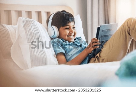 Child, tablet and smile with headphones on bed for online games, watch movies or play educational app. Happy boy kid listening to multimedia, music or streaming cartoon in bedroom on digital tech