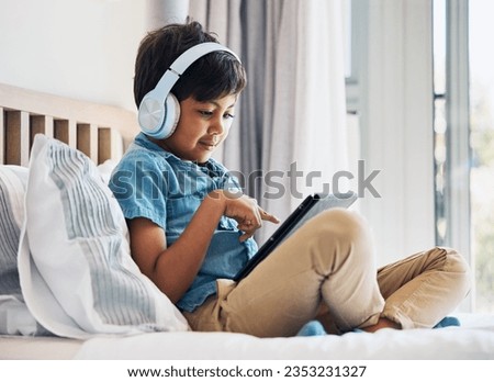 Boy, kid and headphones with tablet on bed for online games, watching movies or play educational app. Happy child, digital technology or listening to multimedia, music or streaming cartoon in bedroom