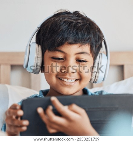 Face of kid, headphones and tablet in home for reading ebook, watch movies and play video game on elearning app. Happy boy child, digital tech and listening to multimedia, music and streaming cartoon