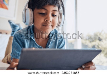 Boy kid, tablet and headphones on bed, reading or idea with e learninng, movie and relax with web video. Male child, digital touchscreen and thinking in bedroom for audio, show and streaming in home