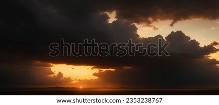View of the sunset sky with dark clouds. Mountain silhouettes in the distance, wide landscape