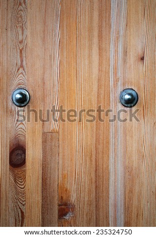 Wooden board with two iron bolts photographed close-up
