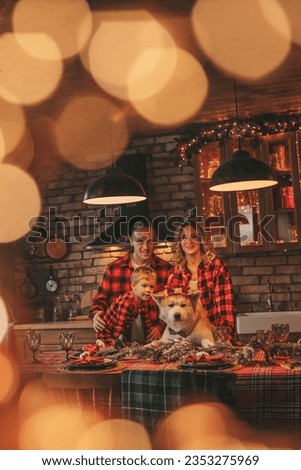 Portrait of happy family with son in red plaid pajamas laughing hugs kisses at home eve 25 december. Celebrating new year noel cozy snuggle warm weather garlands lights hugging his cute akita inu dog