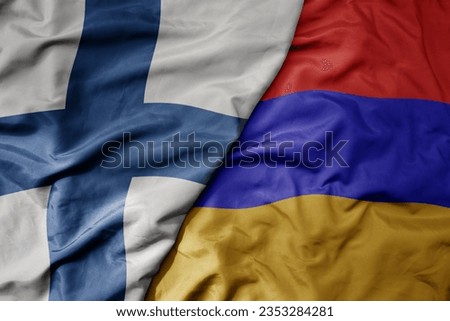 big waving national colorful flag of finland and national flag of armenia . macro