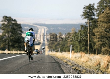 Athlete on a bicycle in action during the Race across America on the road from Flagstaff to Navaho land Royalty-Free Stock Photo #2353288839
