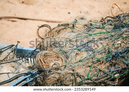 Piles of fishermen fishing nets after being used to catch fish in the sea laid on shore during sunny day with white sand backgrounds at Ngrenehan Beach, Gunungkidul, Jogja