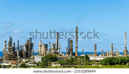oil refinery facroty, recycle of oil and petroleum in green outdoor nature, oil storage facility in industrial zone against green gardens and blue sky on background