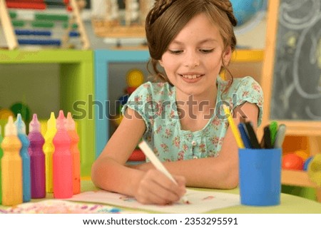Close up portrait of cute girl drawing picture at home