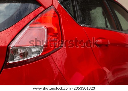 Red car with tail lights. Car parking in backyard. Red hatchback car. Urban transportation. Travel concept. Modern auto in parking lot. Parked auto at the yard.