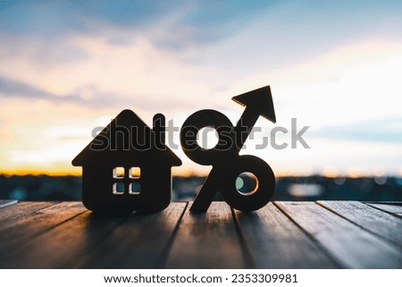 Silhouette of Percentage and house sign symbol icon wooden on wood table. Concepts of home interest, real estate, investing in inflation home loan interest rate hike.