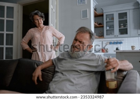 Angry aged wife scolding her drunk senior husband