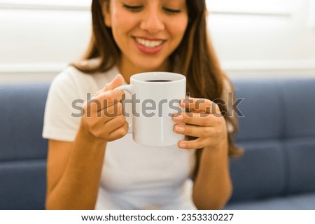 Cheerful mexican young woman looking happy drinking coffee on a 11 oz white mock-up mug 