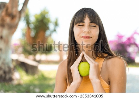 Young woman at outdoors holding an apple