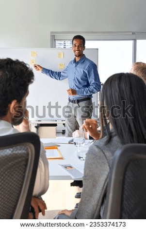 African business man presenter team leader giving presentation training on whiteboard in office. Company executive manager presenting corporate strategy at group conference workshop meeting. Vertical Royalty-Free Stock Photo #2353374173