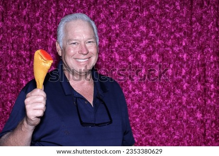 Photo Booth. Chicken Leg. A man smiles as he shows off his Plastic Chicken Leg while having his picture taken in a Photo Booth. Chicken Leg Dog Toy. Plastic Chicken Thigh. Squeekie toy. Poultry Legs. 