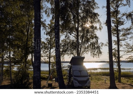 Camper van parking on a beautiful camping pitch at a lake in Sweden.