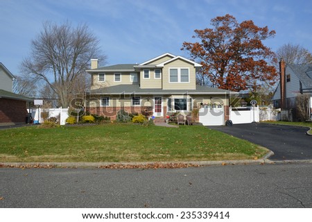 Suburban Mcmansion style home autumn day residential neighborhood blue sky clouds USA