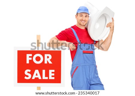 Plumber standing by a for sale sign and carrying a toilet isolated on white background