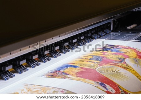 Industrial printing on woven material; modern digital inkjet printer puts a blue pattern picture on a cloth canvas