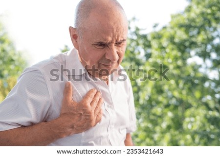 senior, mature man 60-65 years old holds to heart, sudden chest pain, close up male face with facial expression suffering, Ischemic heart disease, Arterial hypertension, Myocarditis or Arrhythmia Royalty-Free Stock Photo #2353421643
