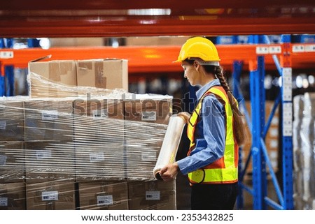 worker wrapping boxes in stretch film at warehouse. stock and inventory in retail warehouse logistics.