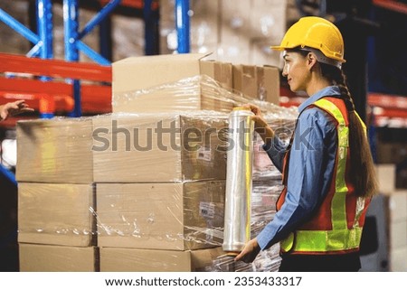 worker wrapping boxes in stretch film in warehouse. stock warehouse logistics concept.