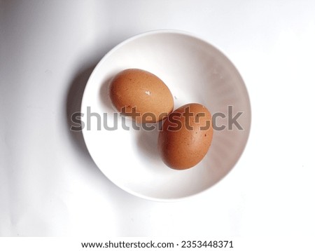 two cooked and uncooked chicken eggs. for a calorie deficit diet breakfast. high protein healthy food. the eggs isolated on white