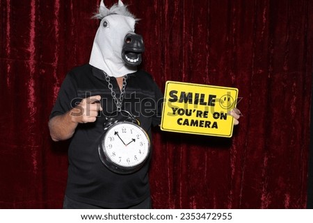 Photo Booth. A man wears a Horse Head Mask and poses while his pictures are taken in a Photo Booth. Party Photo Booth. Wedding Photo Booth. Holiday. Horsing Around. Fun Smile your on Camera Sign. FUN
