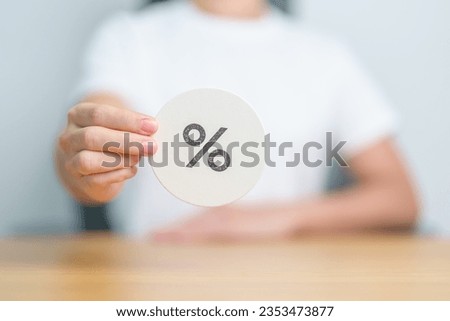 Woman show percentage symbol paper. Interest rate, financial, ranking, discount and promotion and mortgage rates concept Royalty-Free Stock Photo #2353473877