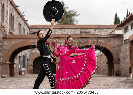 Latin couple of dancers wearing traditional Mexican dress from Guadalajara Jalisco Mexico Latin America, young hispanic woman and man in independence day or cinco de mayo parade or cultural Festival Royalty-Free Stock Photo #2353498439