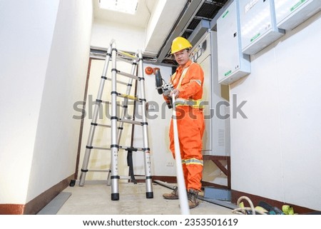 electrician builder engineers workers installing control room cable into fuse box.electrician worker inspecting