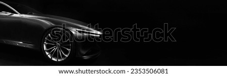 Silhouette of black sports car with one LED headlights on black background,copy space	