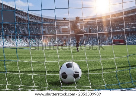 soccer player kicks the ball into the goal at the stadium Royalty-Free Stock Photo #2353509989