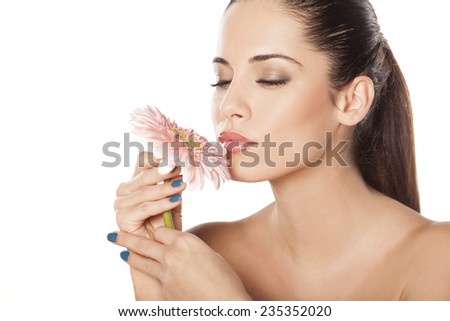 young beautiful woman enjoying the scent of the flower gerbera