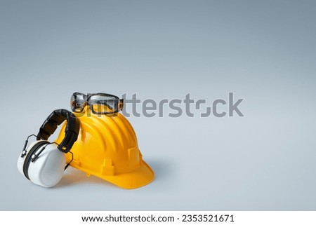 Safety helmet, ear muffs and goggles: personal protective equipment and workplace safety concept Royalty-Free Stock Photo #2353521671