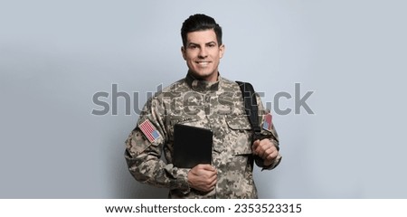 Military education. Cadet with backpack and tablet on light grey background