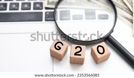 G20. Politics, economics and the concept of cooperation. Magnifying glass on a white background.