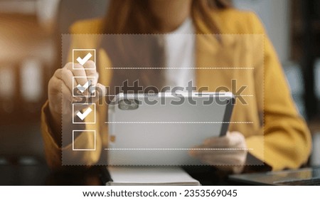 Business woman using tablet to do online checklist survey, doing assessment online survey answer test questions Digital form. Royalty-Free Stock Photo #2353569045