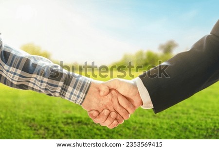 Business concept. Business handshake land purchase. Empty dry cracked swamp reclamation soil in real estate sale or property investment concept. Agriculture land plot for sales. Royalty-Free Stock Photo #2353569415