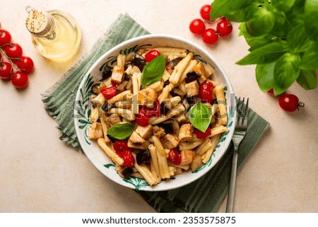 Top view of Italian, Sicilian dinner. Pasta with swordfish, tomato, and eggplant. Olive oil, vegetables. Royalty-Free Stock Photo #2353575875