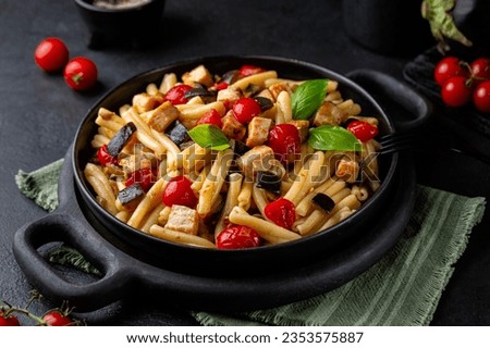 Sicilian pasta, casarecce with swordfish, tomato, and eggplant. Decorated with basil leaves. Dark table surface. Royalty-Free Stock Photo #2353575887