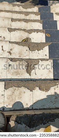 a pedestrian staircase with cracked and broken ceramic tile cladding