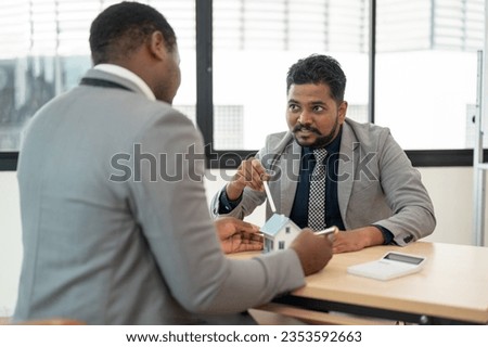 A professional Indian businessman is having a meeting with an African American real estate agent in the office. Diverse businesspeople, property investment Royalty-Free Stock Photo #2353592663