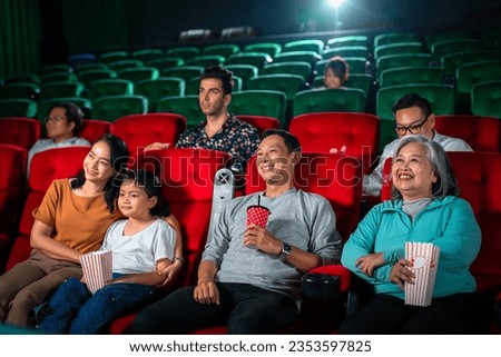 Happy group of asian family and grandmother relax and go to Cimema in movie theater and buy ticket and popcorn in sales counter service