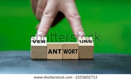 Hand turns wooden cubes and changes the German word 'Antwort' (answer) to 'Verantwortung' (responsibility).