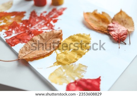 Children's autumn activity, leaf print on paper.